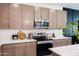 Modern kitchen with stainless steel appliances, quartz countertops, and stylish cabinetry at 651 N Ironwood Dr # 2, Apache Junction, AZ 85120