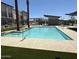 A community pool, featuring palm trees and views of nearby buildings at 651 N Ironwood Dr # 3, Apache Junction, AZ 85120