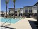 The refreshing community pool with clear water, palm trees, and residential buildings in the background at 651 N Ironwood Dr # 3, Apache Junction, AZ 85120