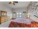 Lovely bedroom featuring a patterned accent wall, ceiling fan, and French doors at 669 W Chaparral Rd, Wickenburg, AZ 85390