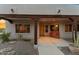 Inviting front porch with wood accents, desert landscaping, and a cozy bench with red pillows at 669 W Chaparral Rd, Wickenburg, AZ 85390