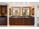 Elegant bathroom featuring dual sinks, granite countertops, and dark wood cabinetry at 7175 E Camelback Rd # 307, Scottsdale, AZ 85251