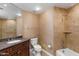 Well-lit bathroom with a granite vanity, bathtub, shower, and tiled walls at 7175 E Camelback Rd # 307, Scottsdale, AZ 85251