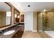 Elegant bathroom with double sinks, dark wood cabinets, and glass-enclosed shower at 7175 E Camelback Rd # 307, Scottsdale, AZ 85251
