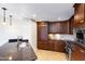 Elegant kitchen featuring dark wood cabinetry, marble countertops, and stainless appliances at 7175 E Camelback Rd # 307, Scottsdale, AZ 85251
