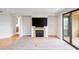 Open living room with fireplace, flat screen tv, and doors to the kitchen and balcony at 7175 E Camelback Rd # 307, Scottsdale, AZ 85251