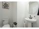Charming half bathroom featuring a pedestal sink, round mirror, and stylish cactus art on the wall at 778 E Harper St # 101, Gilbert, AZ 85297