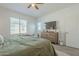 Bright bedroom featuring a large window, dresser with television, and modern ceiling fan at 778 E Harper St # 101, Gilbert, AZ 85297