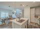 Bright open-concept kitchen with a waterfall island, pendant lights, wood-look floors, and a view of the dining area and staircase at 778 E Harper St # 101, Gilbert, AZ 85297