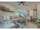 Cozy living room featuring a plush gray sofa, decorative accents, wood-look flooring, and open access to the dining area and kitchen at 778 E Harper St # 101, Gilbert, AZ 85297