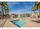 Community pool and hot tub featuring lounge chairs, palm trees, and blue skies at 778 E Harper St # 101, Gilbert, AZ 85297