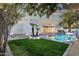 Gorgeous backyard view featuring pool and outdoor living, surrounded by green grass and palms at 8713 N 80Th Pl, Scottsdale, AZ 85258