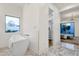 Bright bathroom featuring a soaking tub, marble floor, and view to the outside at 8713 N 80Th Pl, Scottsdale, AZ 85258