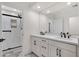 Modern bathroom with a double sink vanity, sleek black fixtures, and a luxurious glass-enclosed shower at 8713 N 80Th Pl, Scottsdale, AZ 85258