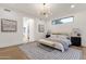 Bright bedroom features a modern chandelier, a large window, and minimalist decorations and furniture at 8713 N 80Th Pl, Scottsdale, AZ 85258