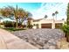 Beautiful home showcasing a well manicured front lawn, desert trees and an inviting paver driveway leading to a two car garage at 8713 N 80Th Pl, Scottsdale, AZ 85258