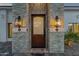 Close up of the front door in a stone facade with elegant lighting at 8713 N 80Th Pl, Scottsdale, AZ 85258