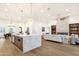 Open concept living space with a large kitchen island, fireplace, and dining area under modern lighting fixtures at 8713 N 80Th Pl, Scottsdale, AZ 85258