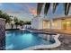 Modern pool with attached spa and waterfall feature are showcased in spacious yard with contemporary architecture at 8713 N 80Th Pl, Scottsdale, AZ 85258