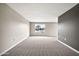 Empty room with neutral carpet and gray accent wall with window view at 9751 W Royal Ridge Dr, Sun City, AZ 85351