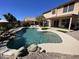 Gorgeous backyard featuring a pool with rock accents, a covered patio, and lush landscaping, perfect for outdoor living at 9761 W Yukon W Dr, Peoria, AZ 85382