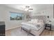 Bright primary bedroom featuring a ceiling fan, plush rug, and bench seating with a scenic outdoor view at 1050 N 84Th Pl, Scottsdale, AZ 85257