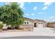 Charming single-level home featuring a lush tree, three-car garage, and desert landscaping at 10630 W Pinchot Ave, Avondale, AZ 85392