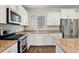 Well-lit kitchen with a stainless steel refrigerator, granite countertops, and bright white cabinetry at 10630 W Pinchot Ave, Avondale, AZ 85392