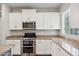 Modern kitchen featuring stainless steel appliances, granite countertops, and white cabinetry at 10630 W Pinchot Ave, Avondale, AZ 85392