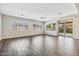 Open living room with wood-look tile, large windows, a sliding glass door, and neutral paint at 10630 W Pinchot Ave, Avondale, AZ 85392