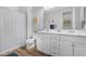 Bright bathroom featuring double sinks with white cabinetry and stylish wood-look flooring at 10633 E Sheffield Dr, Mesa, AZ 85212