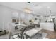 Dining room with chandelier, leading into the kitchen, bathed in sunlight from surrounding windows at 10633 E Sheffield Dr, Mesa, AZ 85212