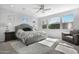 Serene main bedroom featuring natural light, ceiling fan, and a cozy sitting area with a large bed at 10633 E Sheffield Dr, Mesa, AZ 85212