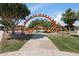 Fun playground with unique orange monster climbing structure amidst lush green lawns and mature shade trees for families to enjoy at 10633 E Sheffield Dr, Mesa, AZ 85212