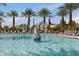 The pool has basketball hoops in the water adding fun activities surrounded by towering palm trees at 10633 E Sheffield Dr, Mesa, AZ 85212