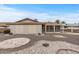 Exterior view of the back of the house with the garage, covered patio, and desert landscaping at 10956 W Meade Dr, Sun City, AZ 85351