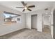 Bright bedroom featuring neutral carpet, a ceiling fan, a closet, and a backyard view at 10956 W Meade Dr, Sun City, AZ 85351