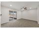 Cozy bedroom featuring soft carpet, ceiling fan and slider door to sun room at 10956 W Meade Dr, Sun City, AZ 85351