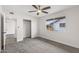 Bright bedroom featuring neutral carpet, a ceiling fan, a closet, and a backyard view at 10956 W Meade Dr, Sun City, AZ 85351