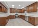 Spacious kitchen featuring dark wood cabinets, stainless steel appliances, and ample countertop space at 10956 W Meade Dr, Sun City, AZ 85351