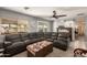 Living room featuring a large brown sectional sofa, a ceiling fan, and a sliding barn door at 11468 N Desert Hills Dr, Sun City, AZ 85351