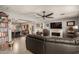 Open concept living room with fireplace, ceiling fan and a large window to adjacent dining room at 11468 N Desert Hills Dr, Sun City, AZ 85351