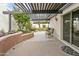 Tranquil backyard patio with a pergola, vibrant flowers, and a seamless transition to indoors at 1216 E Rancho Dr, Phoenix, AZ 85014