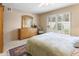 Bright bedroom with a neutral color palette, carpet flooring, and a large window overlooking the backyard at 1216 E Rancho Dr, Phoenix, AZ 85014