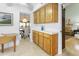 This eat-in kitchen features wood cabinets, a view into the dining area, and tile countertops at 1216 E Rancho Dr, Phoenix, AZ 85014