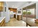 Quaint kitchen with bright white appliances, wood cabinets, and a sliding door with outdoor access at 1216 E Rancho Dr, Phoenix, AZ 85014