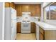 Functional kitchen with white appliances, wood cabinetry, and a tile backsplash at 1216 E Rancho Dr, Phoenix, AZ 85014