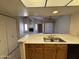 A kitchen view looks into the living room, featuring cabinetry and a sink at 1384 N Santa Anna Ct, Chandler, AZ 85224