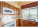 Well-lit kitchen with a stainless steel sink, granite countertops, a white range, and updated cabinetry at 15237 S 47Th Way, Phoenix, AZ 85044