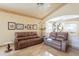 Inviting living room featuring leather couches, ceiling fan and decorative wall art at 15237 S 47Th Way, Phoenix, AZ 85044